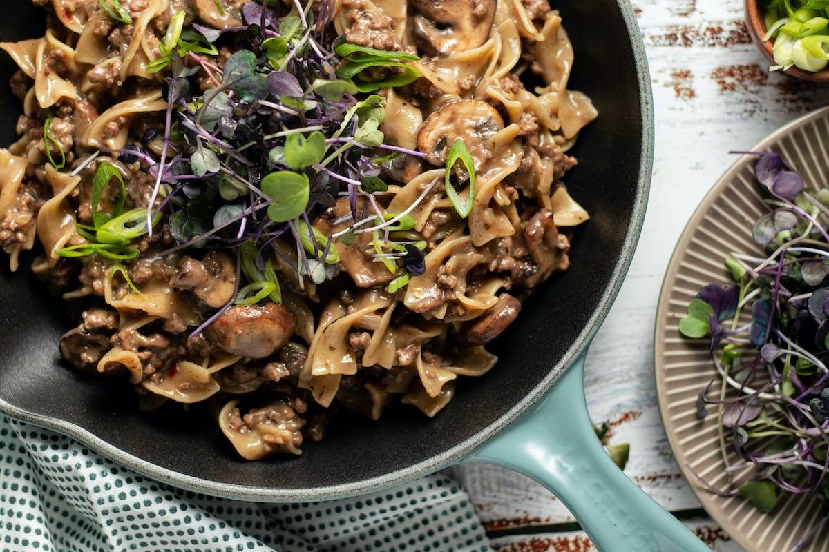 One Pot Beef Stroganoff Recipe, Noodles and beef cooked in a mushroom soup. Cooked in a light blue cast iron pan. Great for meal prep, counting macros, freezer friendly