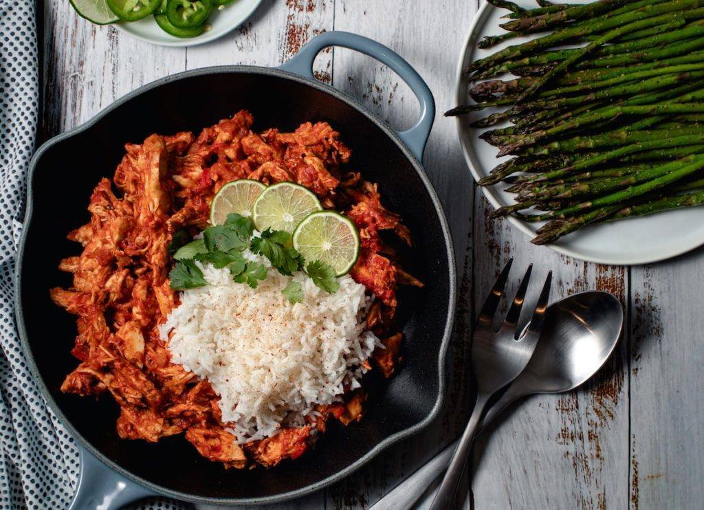 Spiced Tomato & Coconut Chicken w/Rice Served in a cast Iron Pan with a side of Asparagus Meal Planning Meal Prep Counting Macros Macro Friendly