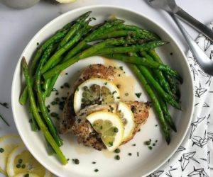 Chicken and Asparagus with Lemon Caper Sauce, Sliced lemons with chives and capers on the table