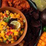 Easy 5 Minute Mango Salsa served in a brown bowl surrounded by multi colored chips