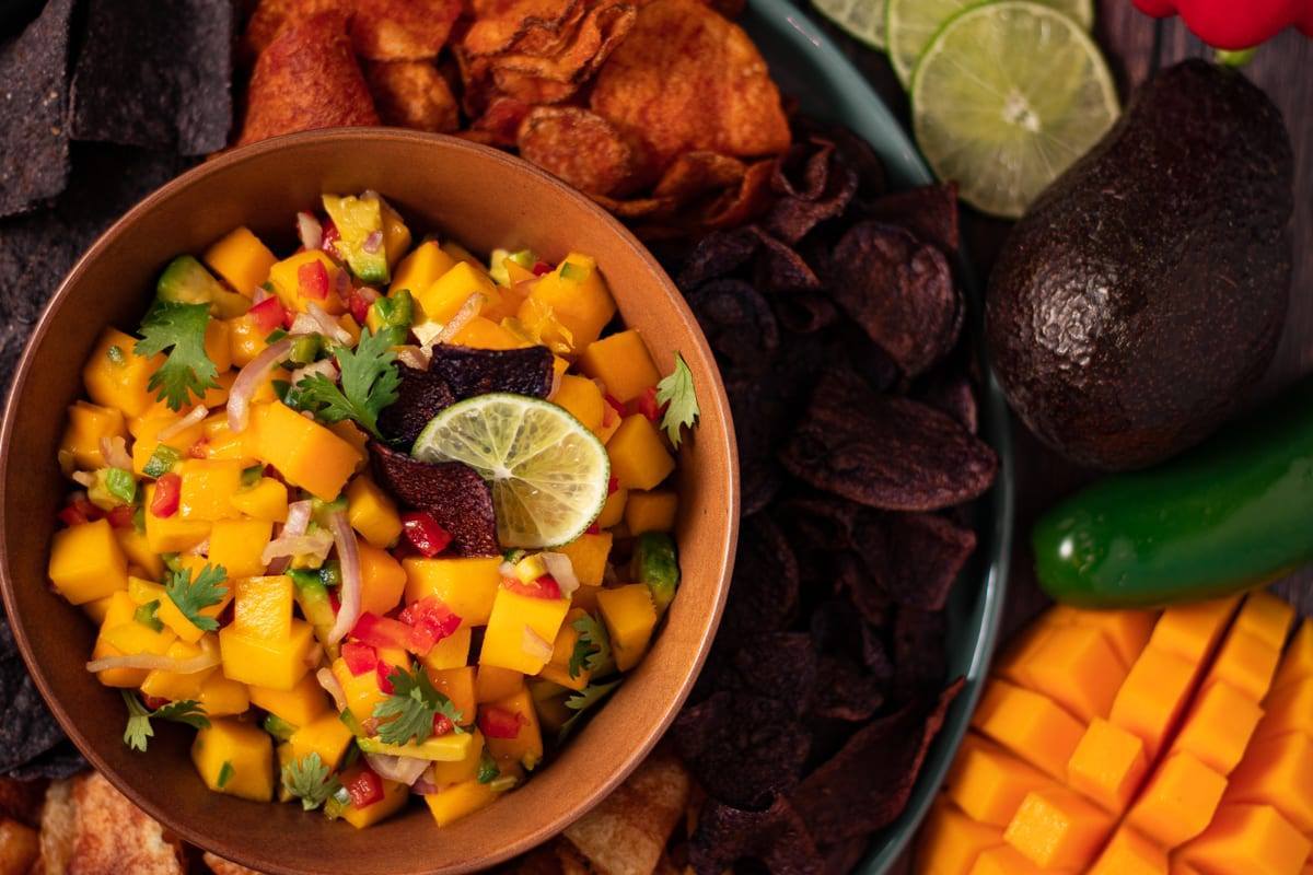 Easy 5 Minute Mango Salsa served in a brown bowl surrounded by multi colored chips